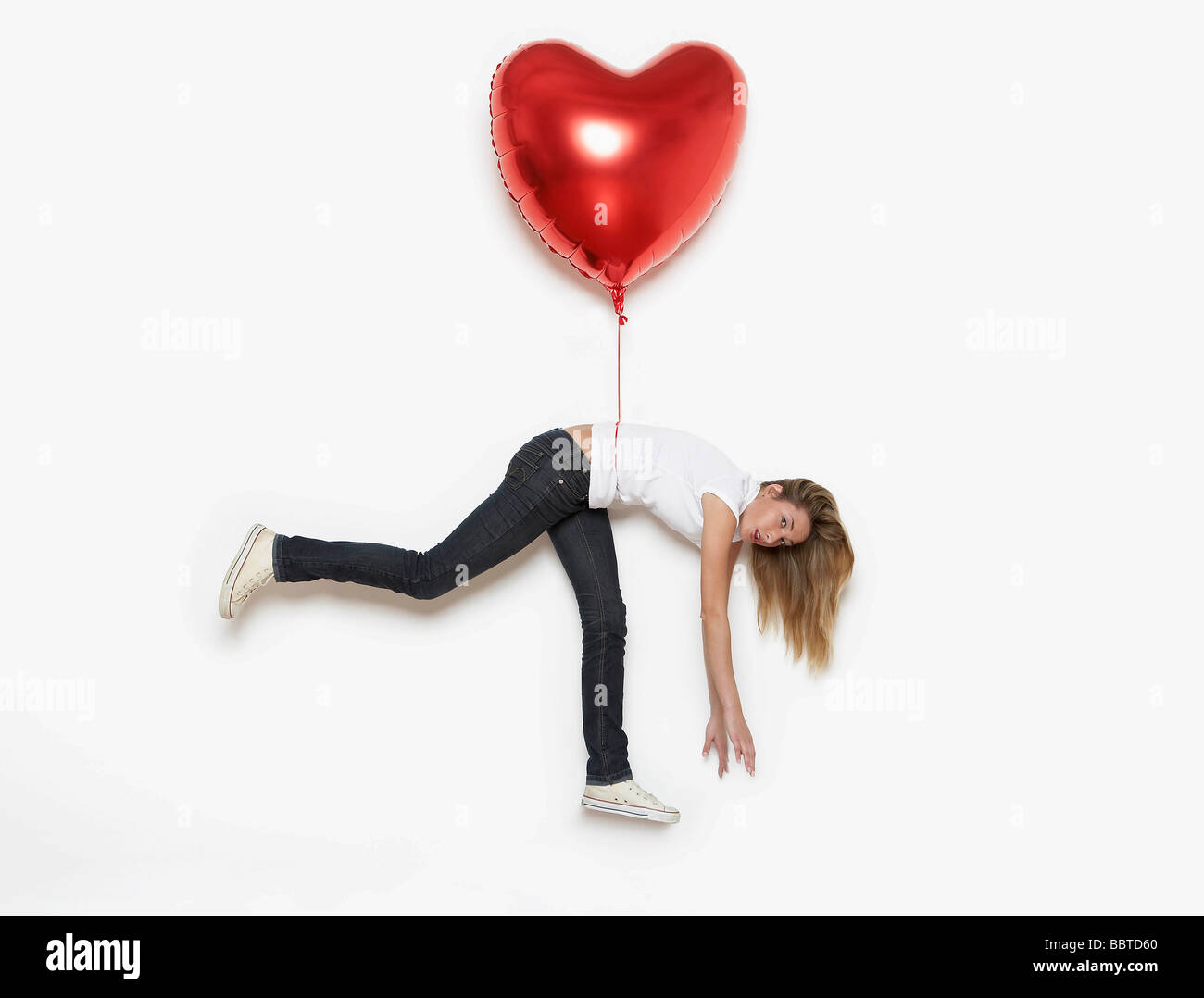 Frau von Herzballon gehoben Stockfoto