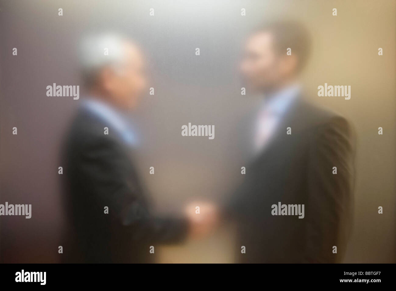 Männer schütteln Hände hinter Bildschirm Stockfoto