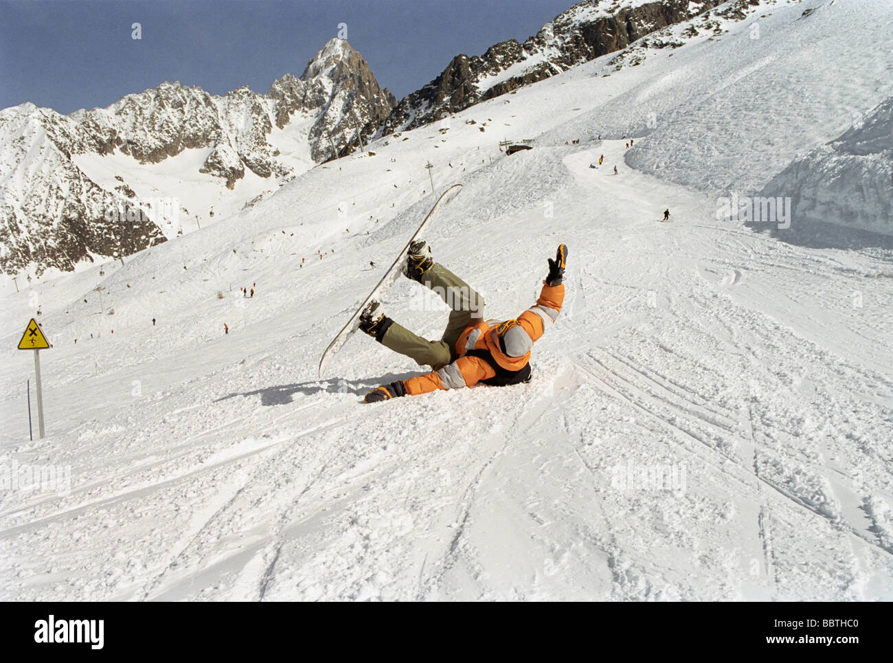 Rollen im Schnee mit einem Snowboard Boy Stockfoto