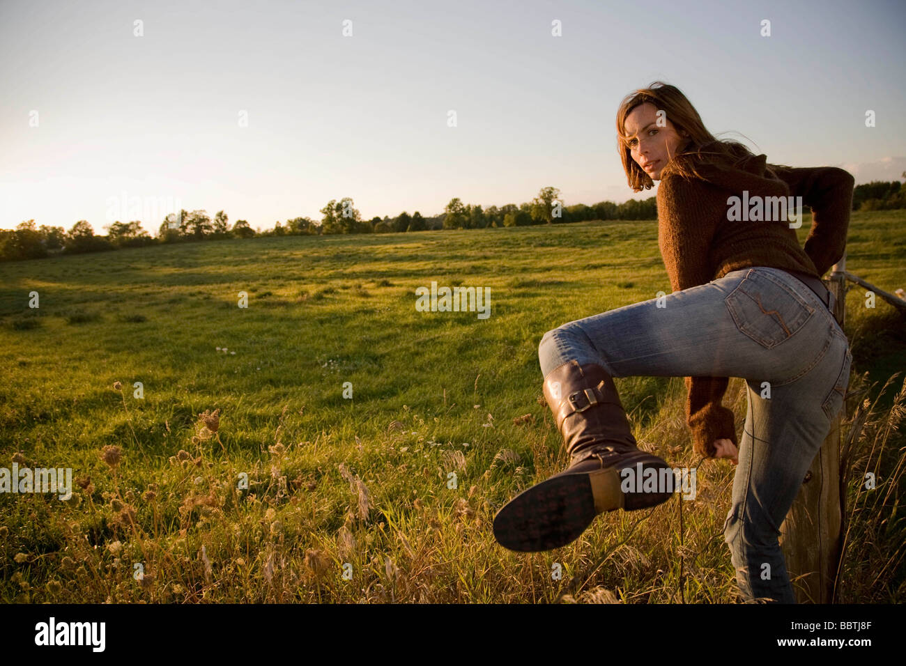 Frau Klettern Zaun Stockfoto