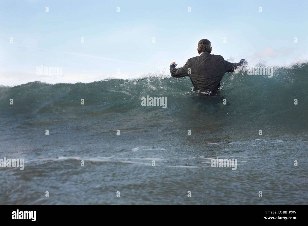 Ein Geschäftsmann ins Meer waten Stockfoto