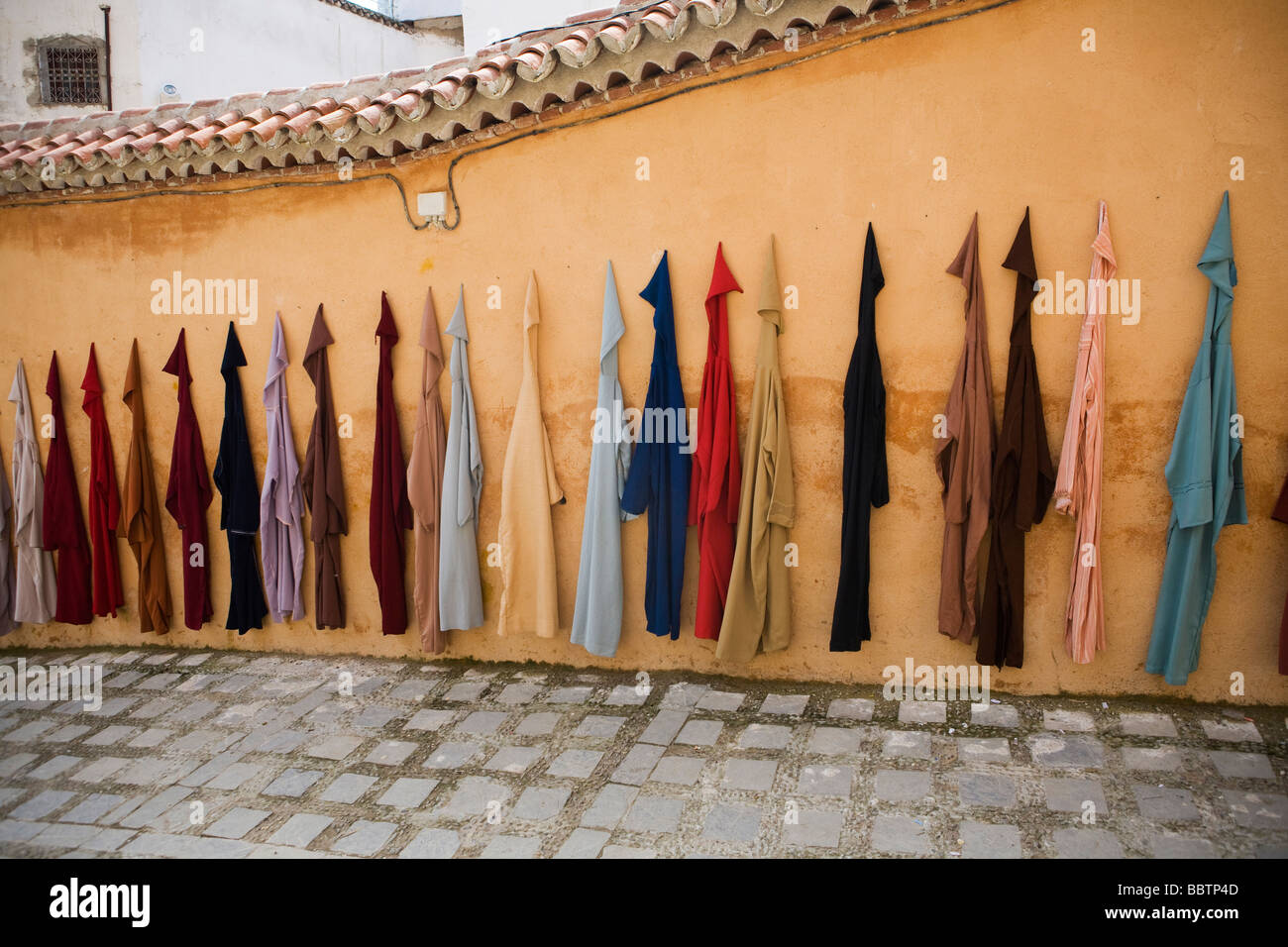 Jellaba Kleidungsstücke hängen an einer Wand, Chefchaouen, Marokko, Nordafrika Stockfoto