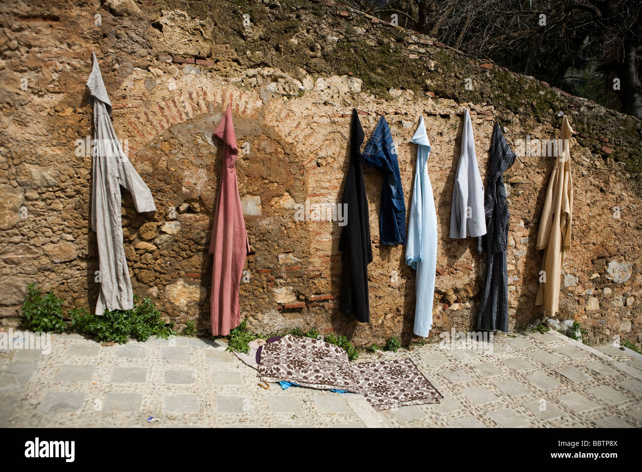 Jellaba Kleidungsstücke hängen an einer Wand, Chefchaouen, Marokko, Nordafrika Stockfoto