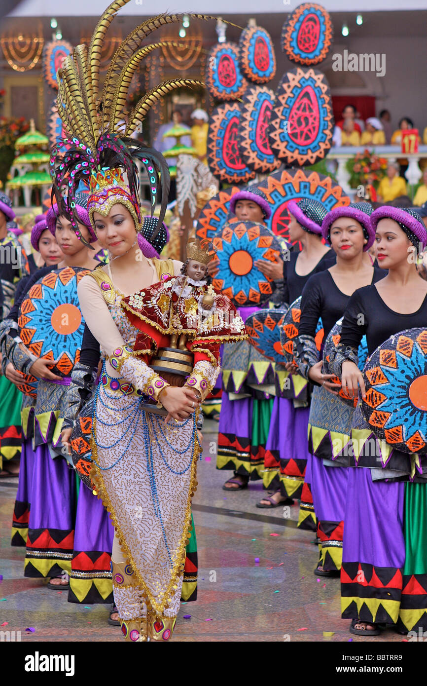 Frau mit Sinulog Kostüm und eine Santo Niño Puppe in der Sinulog-parade Stockfoto