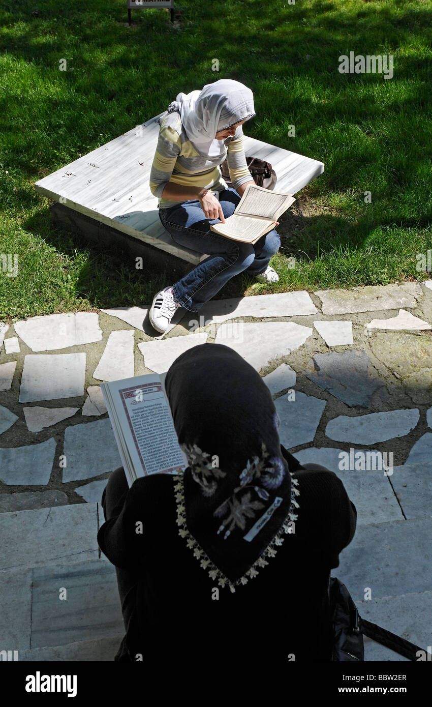 Zwei muslimische Frauen mit Kopftuch lesen den Koran, Garten vor der Prinz-Moschee, Sehzade Camii, Istanbul, Türkei Stockfoto