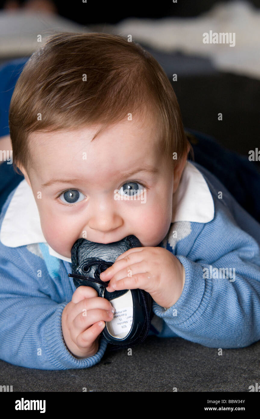 6 Monate altes Baby mit Schuh in den Mund Stockfoto