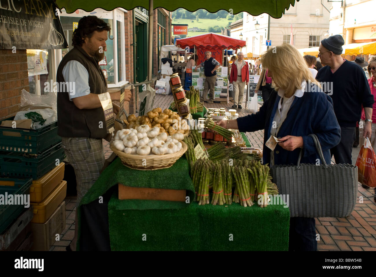 Markt Standbesitzer Verkauf Spargel und Knoblauch in Stroud Farmers' Market Stockfoto