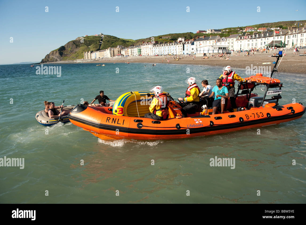 RNLI inshore Rescue Rettungsboot bringen Studierende heraus zum Meer auf Schlauchboot zurück in die Sicherheit des Strandes trieb hatte Stockfoto