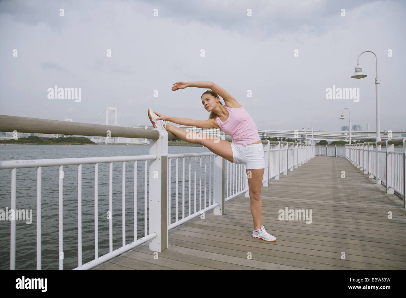 Young Woman stretching Beine auf Brücke Stockfoto