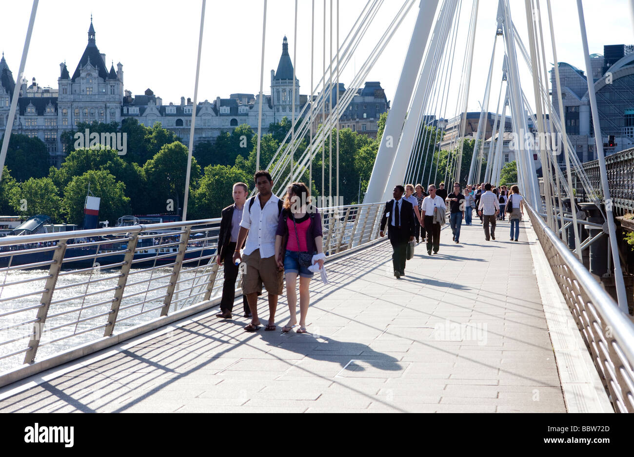 Fußgänger überqueren A-Fuß-Brücke verbunden, Hungerford Railway Bridge London UK Europe Stockfoto