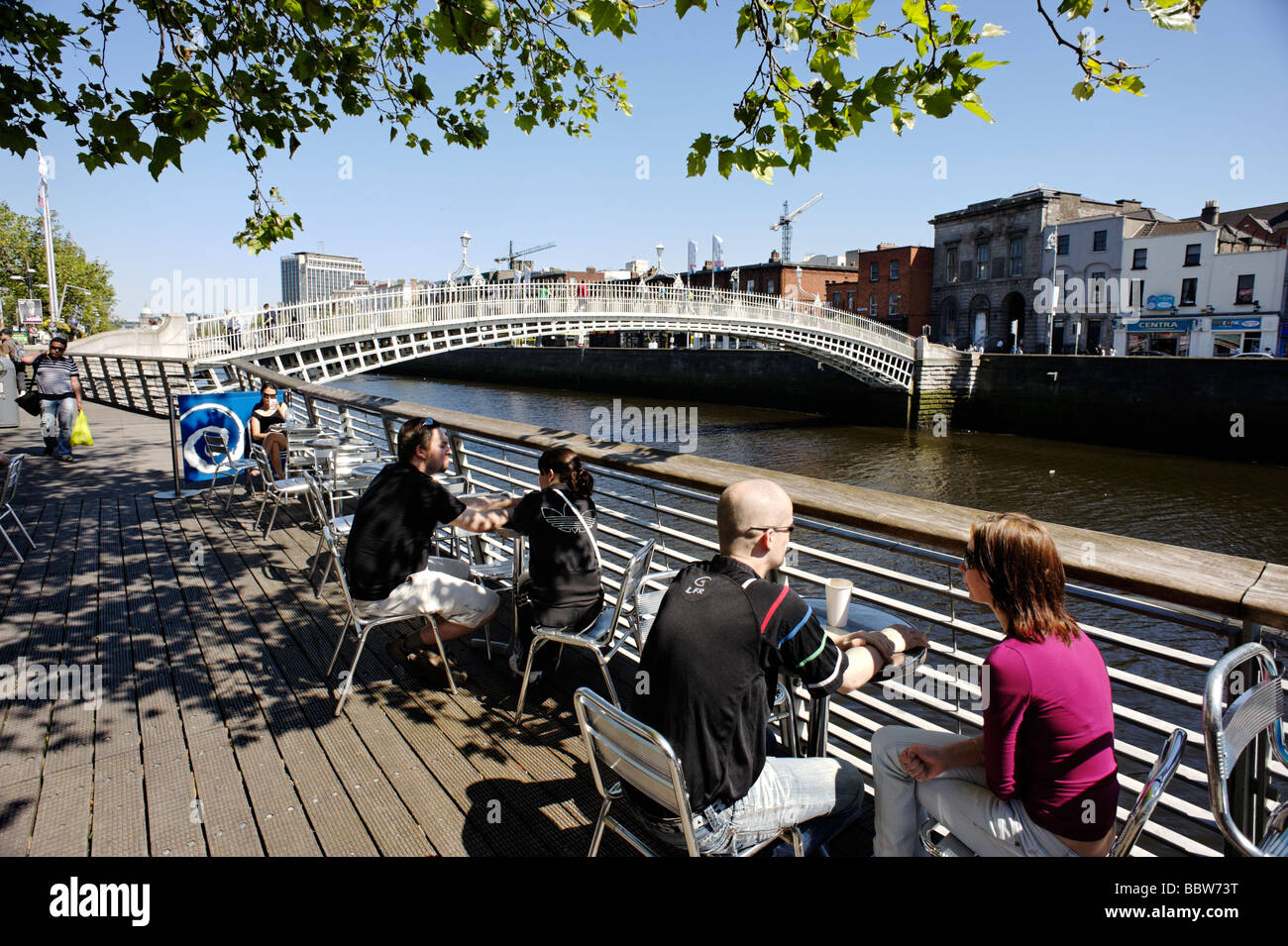 Menschen im Café auf der Liffey-Promenade am unteren Ormond Quay mit Blick auf die Ha Penny bridge zentrale Dublin Irland Stockfoto