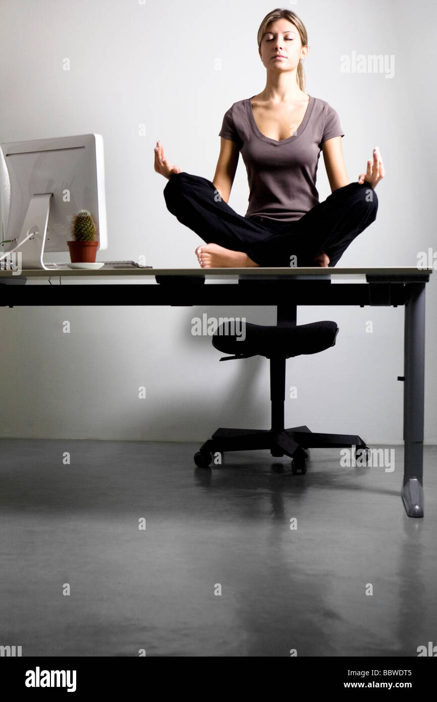 junge Frau beim Yoga am Schreibtisch im Büro Stockfoto ...