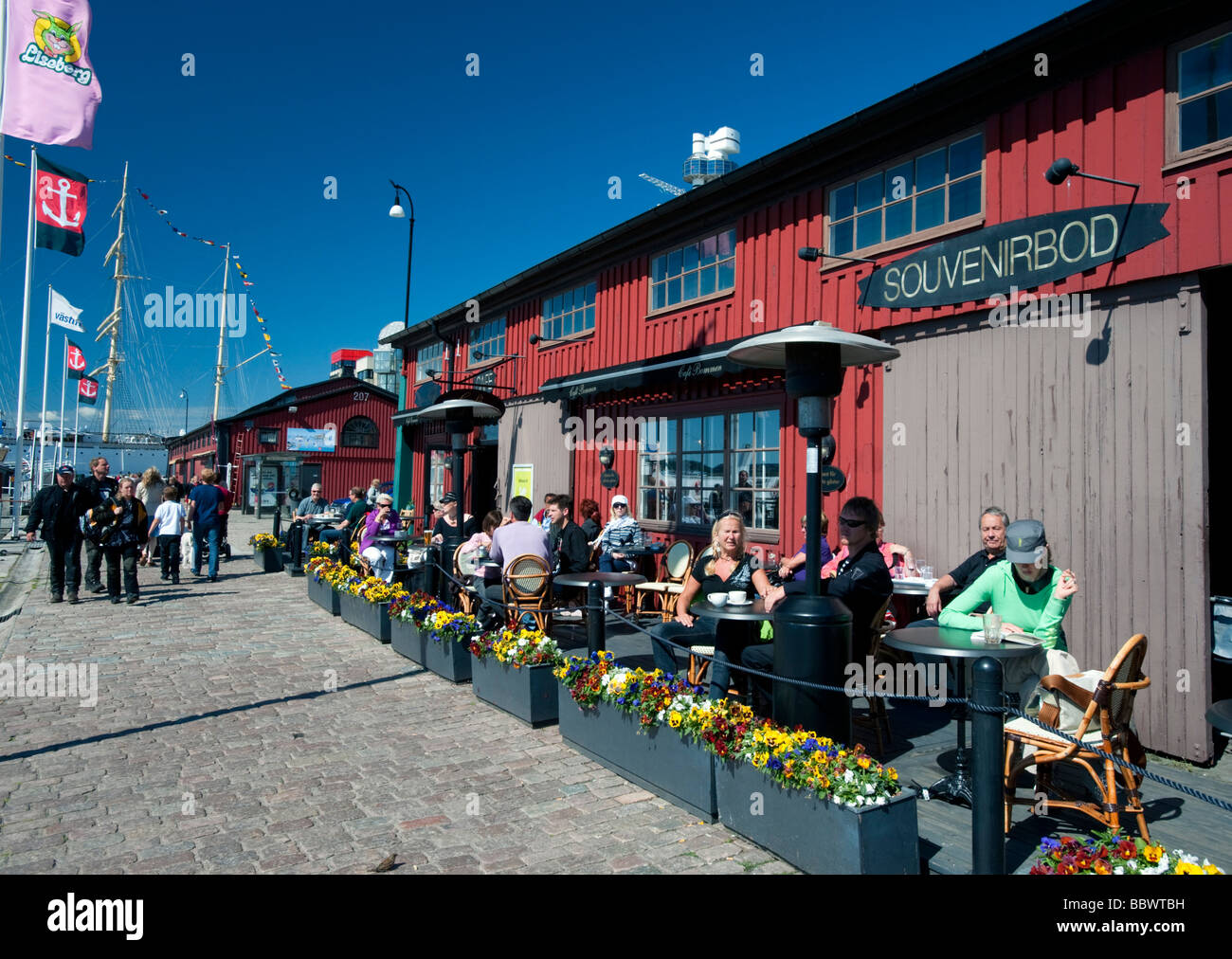 Outdoor-Bar und ein Café im traditionellen historischen roten Holz Lagerhallen und Schuppen im Hafen Lilla Bommen im schwedischen Göteborg Stockfoto