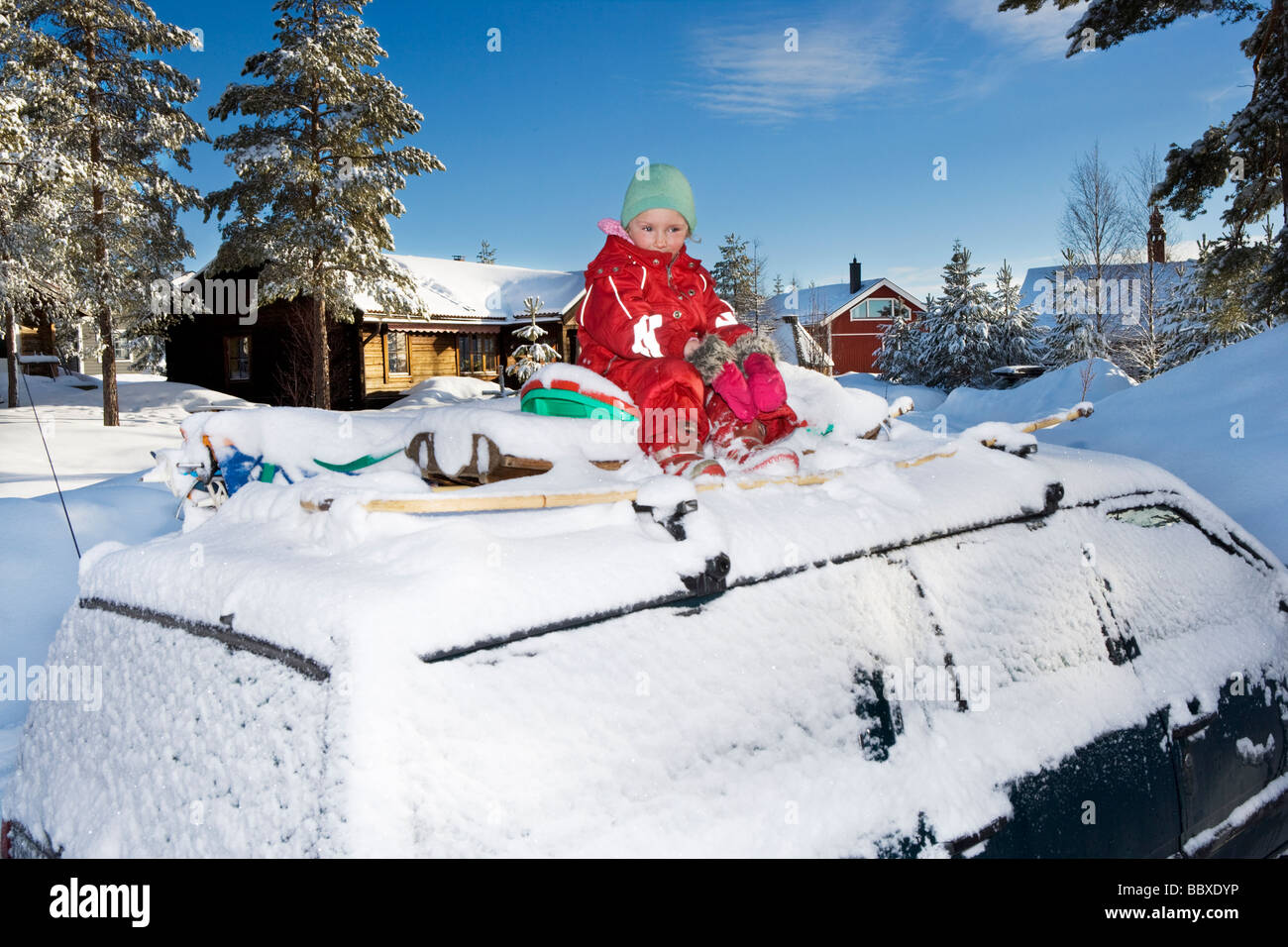 Ein Mädchen sitzt auf dem Dach eines Autos eine Winter-Tag-Schweden. Stockfoto