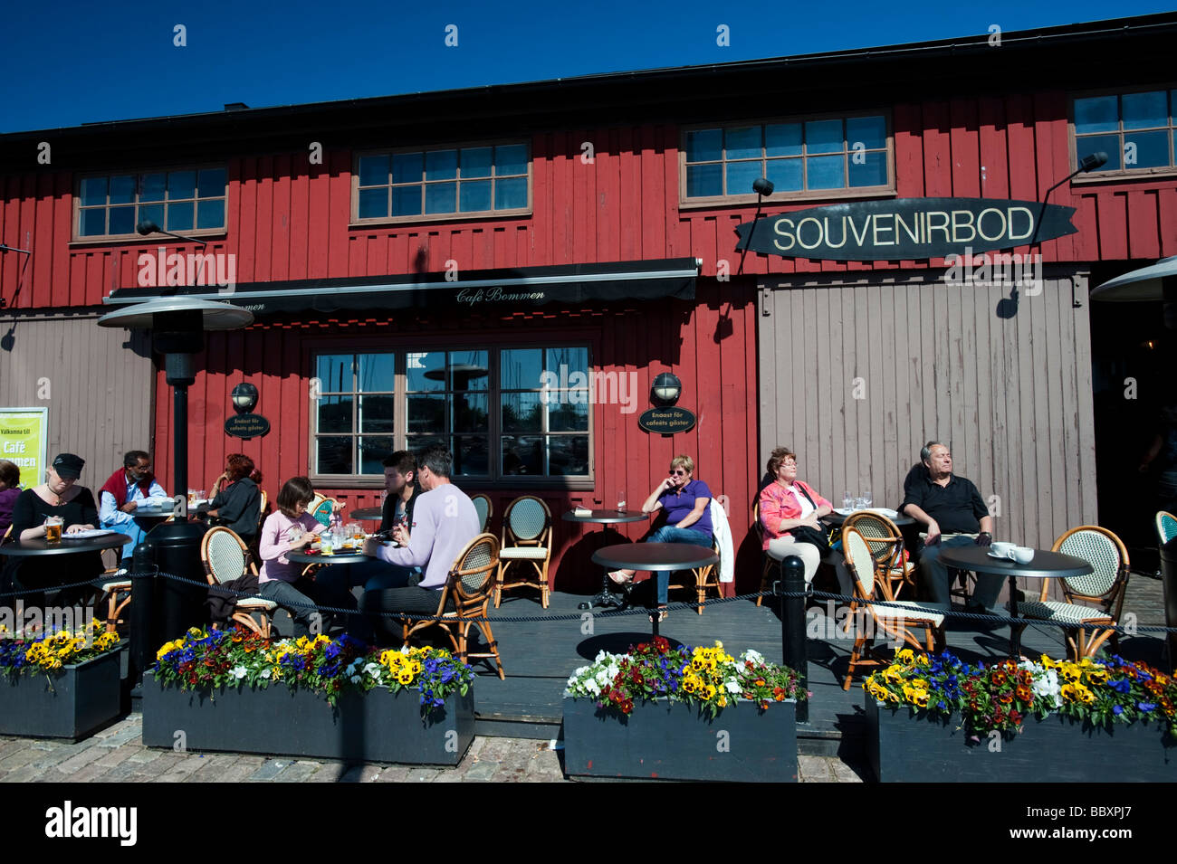 Outdoor-Bar und ein Café im traditionellen historischen roten Holz Lagerhallen und Schuppen im Hafen Lilla Bommen im schwedischen Göteborg Stockfoto