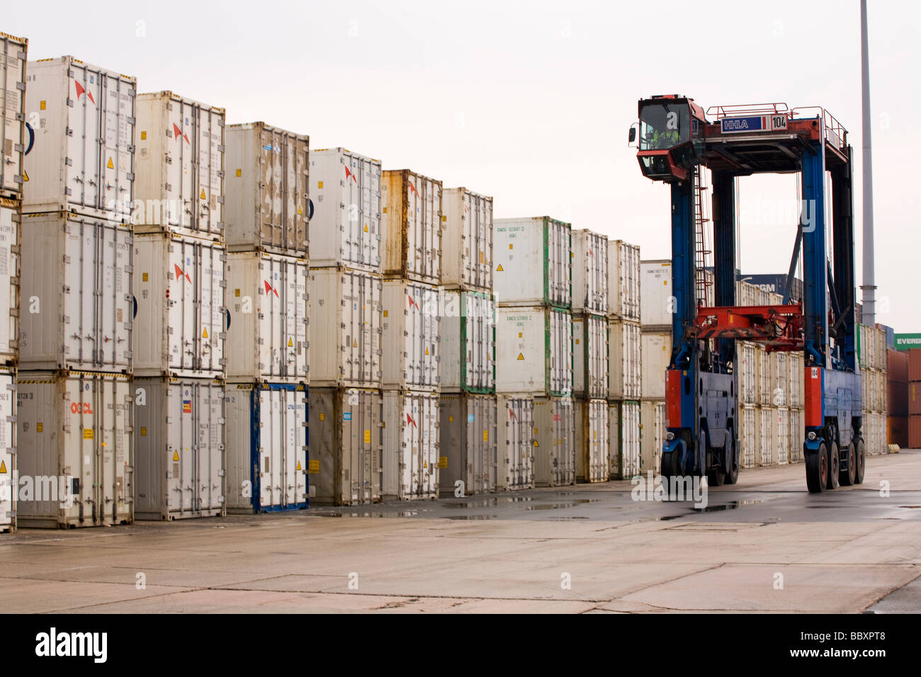 Ein Straddle Carrier LKW bewegt sich ISO-Container um den Container terminal gestapelt und verarbeitet werden. Stockfoto