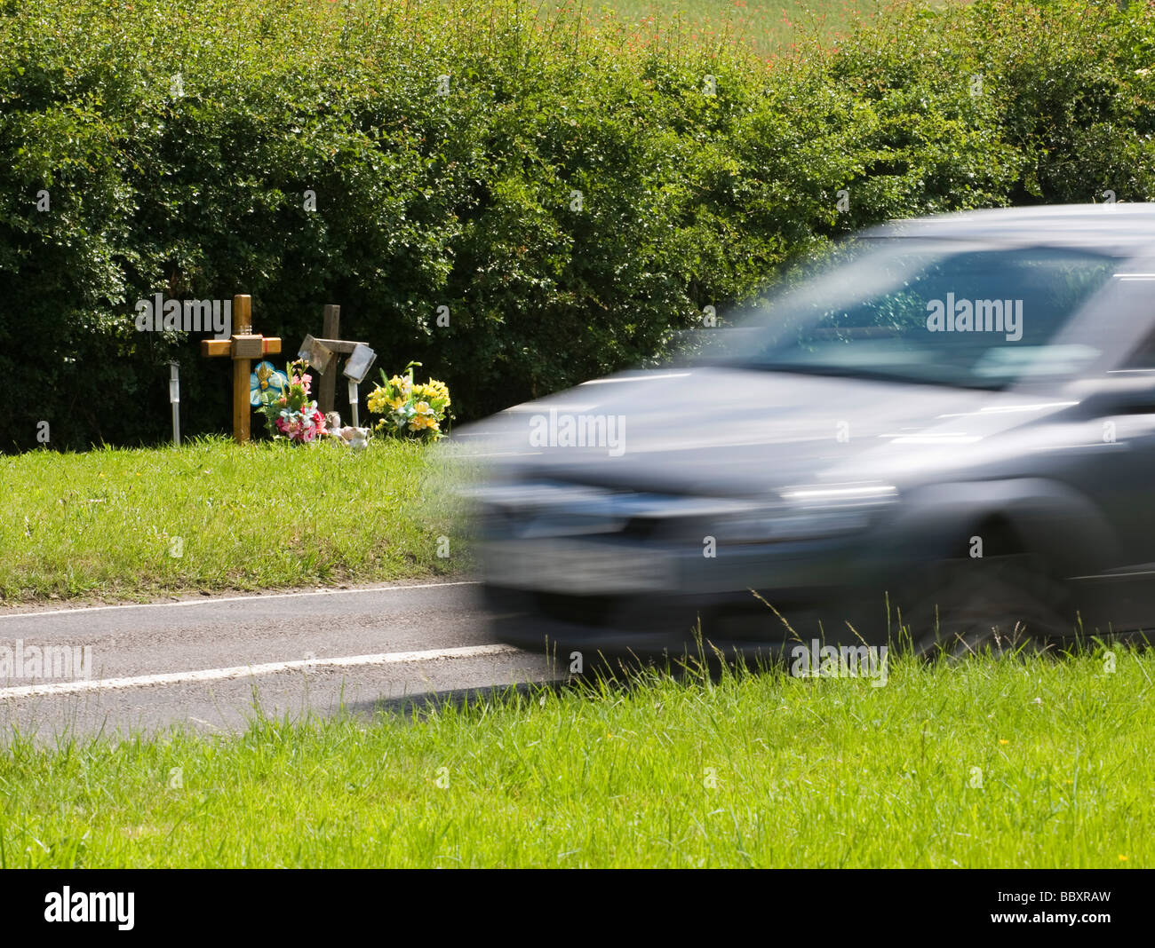 EIN AUTO GESCHWINDIGKEIT VORBEI AN STRAßENRAND DENKMAL, KENNZEICHNUNG EINES FRÜHEREN TÖDLICHEN UNFALLS.  IN DER NÄHE VON CHESHAM, BUCKINGHAMSHIRE Stockfoto