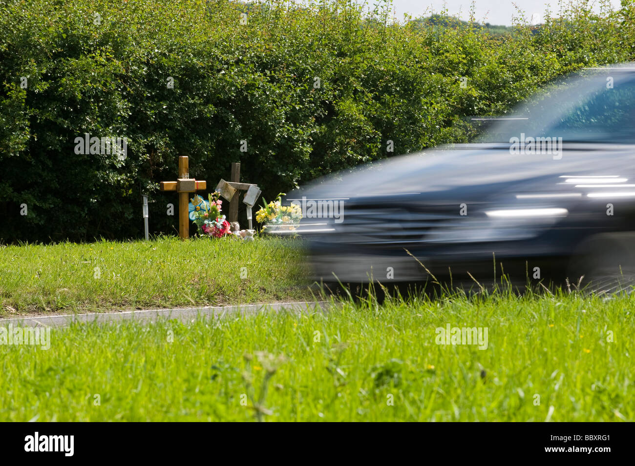 EIN AUTO GESCHWINDIGKEIT VORBEI AN STRAßENRAND DENKMAL, KENNZEICHNUNG EINES FRÜHEREN TÖDLICHEN UNFALLS.  IN DER NÄHE VON CHESHAM, BUCKINGHAMSHIRE Stockfoto