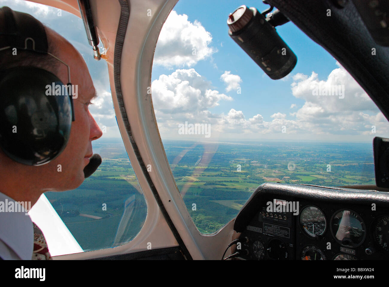 Piloten aus dem Cockpit ein Leichtflugzeug mit blauen Himmel und Landschaft anzeigen Stockfoto