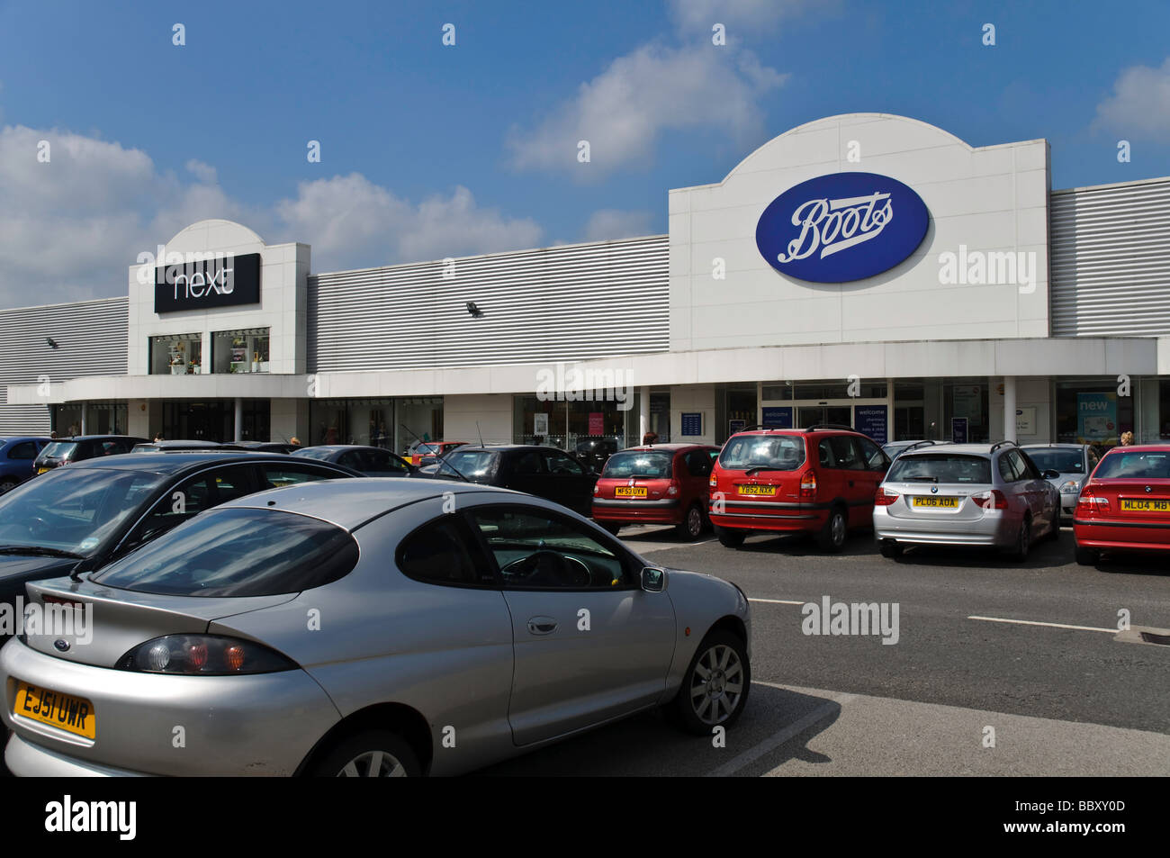 Ein belebter Parkplatz zeigt gute Handelsbeziehungen für Industriezweige weiter "und" Stiefel befindet sich auf der Gemini Retail Park in Warrington, Cheshire. Stockfoto