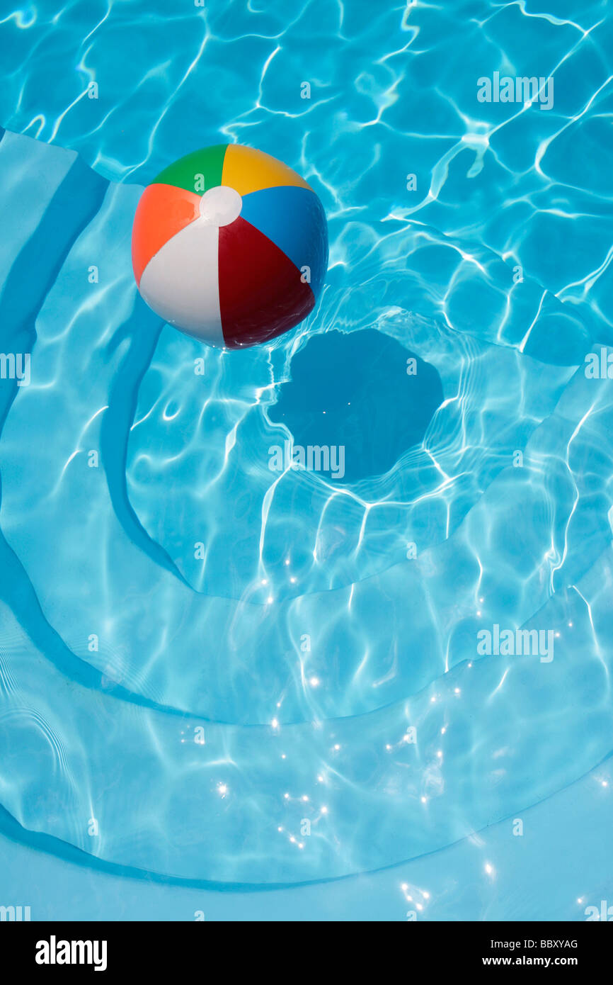Bunte Beachball schweben in einem blauen Swimmingpool Stockfoto