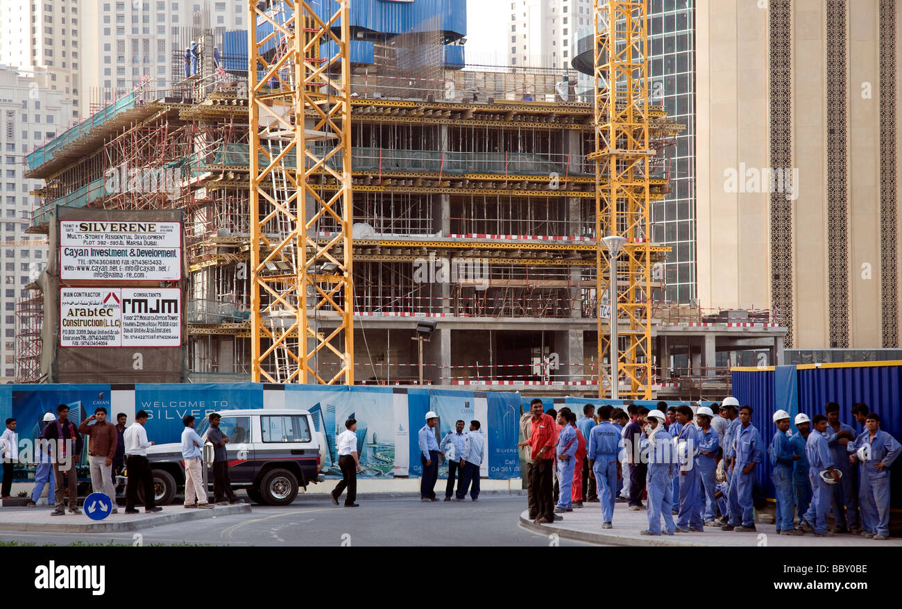In Dubai warten Bauarbeiter am Ende des Tages für den Transport zu ihren Schlafsälen Stockfoto