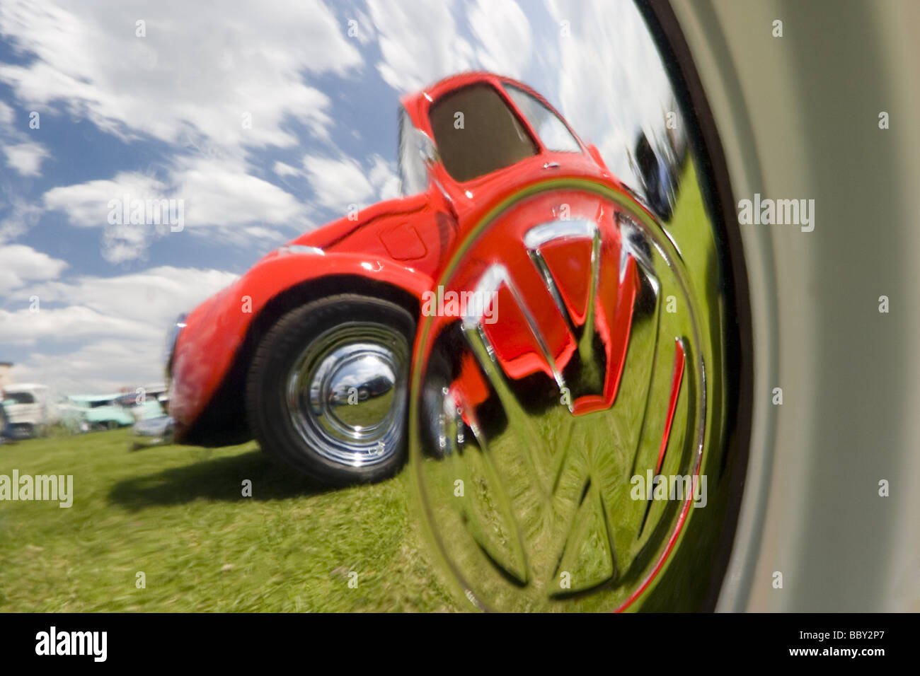 Orange-VW-Käfer spiegelt sich in Chrom VW Nabenkappe Stockfoto