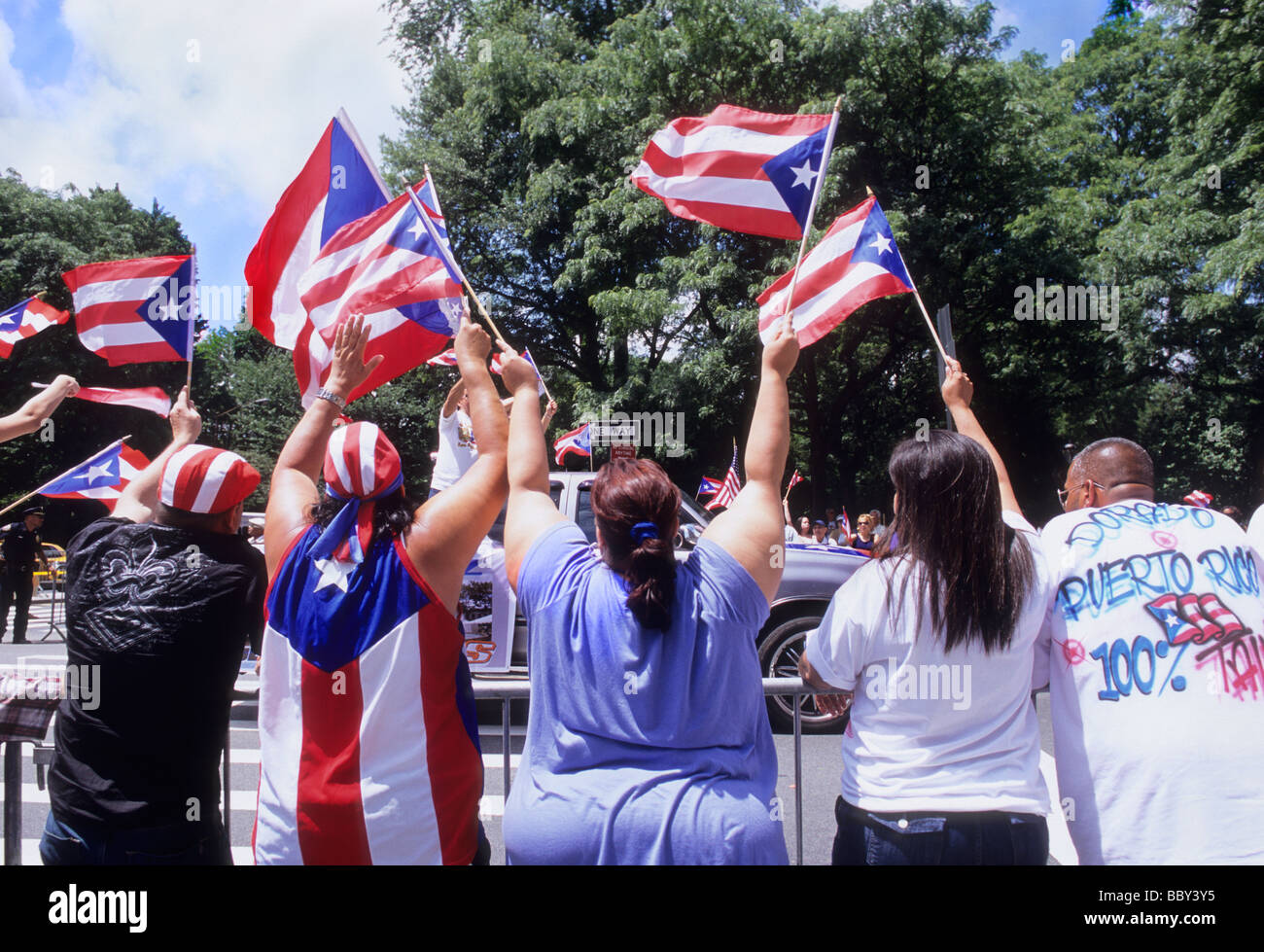 New York City. Die Menge auf der Straße jubelt und schaut der Puerto Rican Day Parade auf der Fifth Avenue zu. Menschen, die Puerto-ricanische Flaggen schwenken Stockfoto