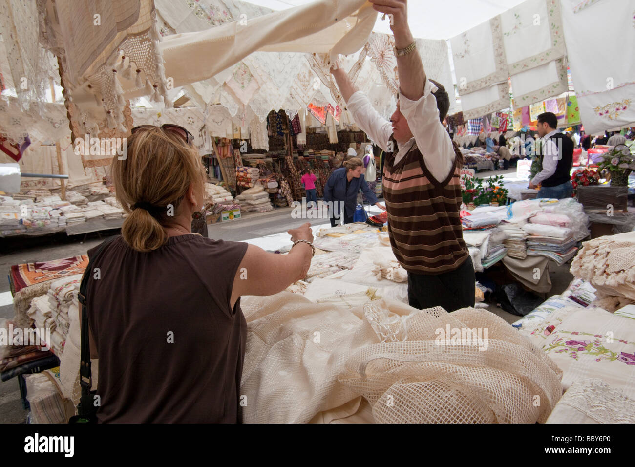 Frau, die Verhandlungen für eine Tischdecke auf einem Markt in der Westtürkei Stockfoto