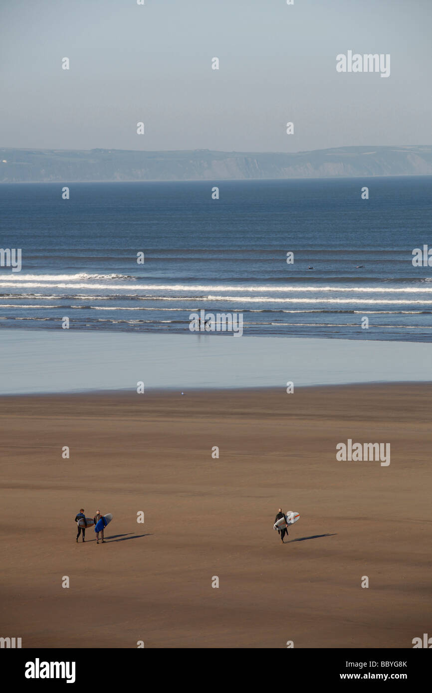 Surfer zu Fuß über den Strand in Richtung Meer. Stockfoto