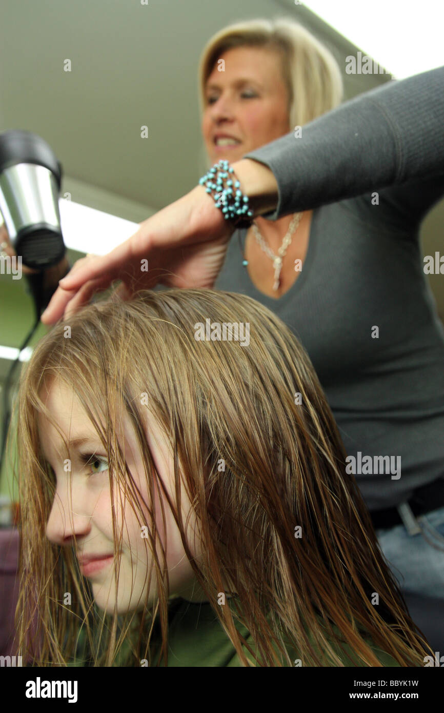 Stylist trocknen Haare eines jungen Kunden Stockfoto