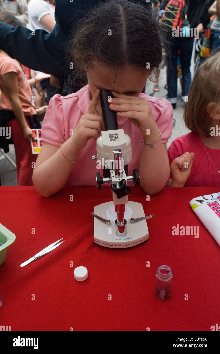 Ein Besucher der World Science Festival Street Fair sieht durch ein Mikroskop Stockfoto