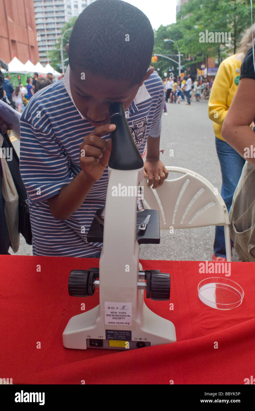 Ein Besucher der World Science Festival Street Fair sieht durch ein Mikroskop Stockfoto