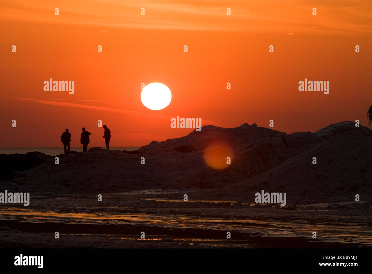 Menschen stehen auf Eisbildung am Strand in New Buffalo Michigan Stockfoto