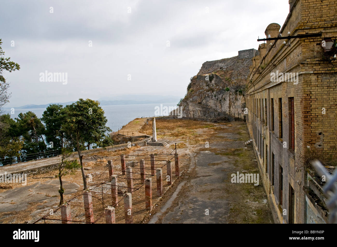 Führt ein Weg zwischen verlassenen Kasernen und eine Konstruktion aus Backstein gebaut, Säulen und ein kleines Denkmal in der alten Festung, Corfu Stockfoto