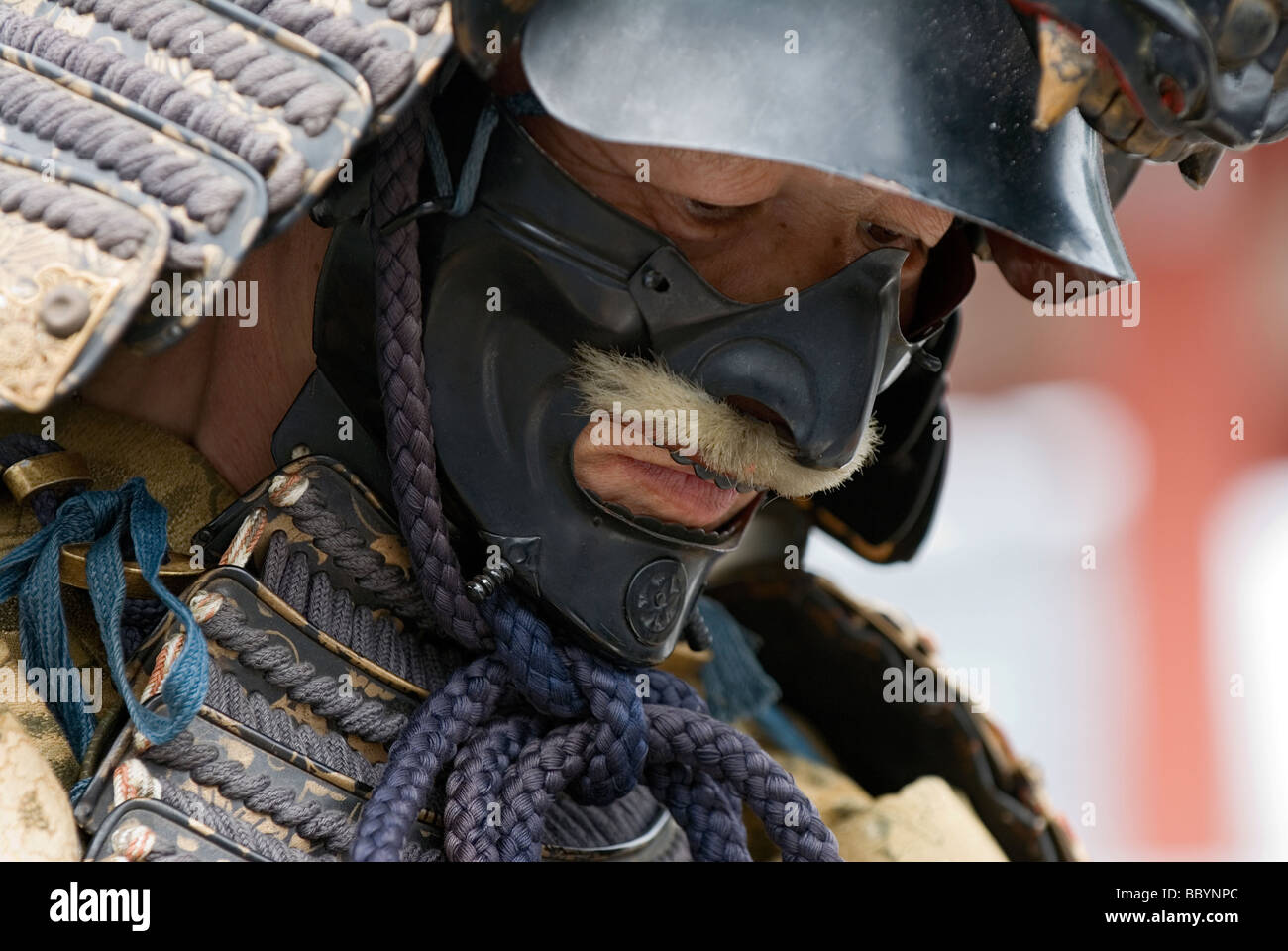 Mann gekleidet in voller Samurai-Rüstung komplett mit Kabuto Helm und Mempo Gesichtsmaske, den Feind einzuschüchtern Stockfoto