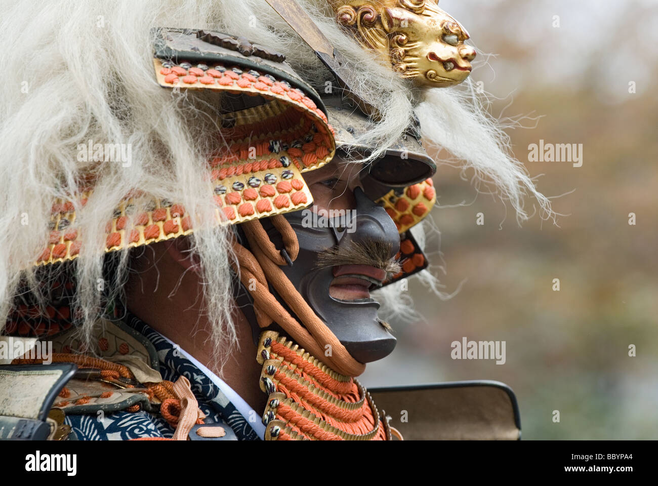 Mann gekleidet in voller Samurai-Rüstung komplett mit Kabuto Helm und Mempo Gesichtsmaske, den Feind einzuschüchtern Stockfoto