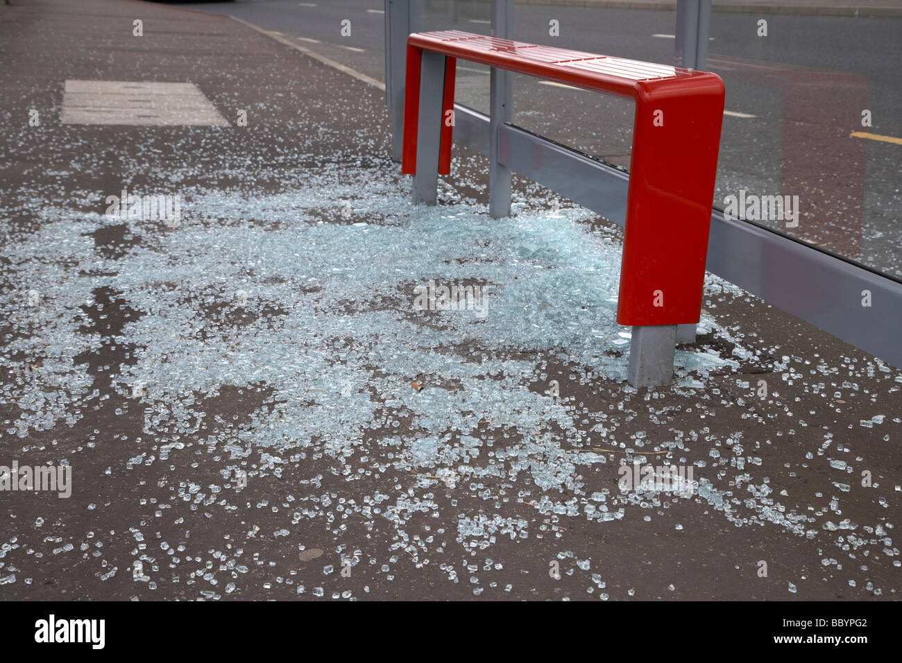 zerbrochene Glas auf dem Boden aus einem geschändeter Bushäuschen in Nordirland Stockfoto