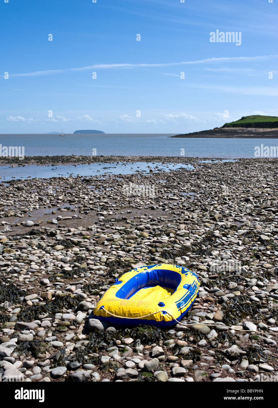 Eine Reifenpanne Schlauchboot am Kieselstrand bei Sully in South Wales aufgegeben. Stockfoto