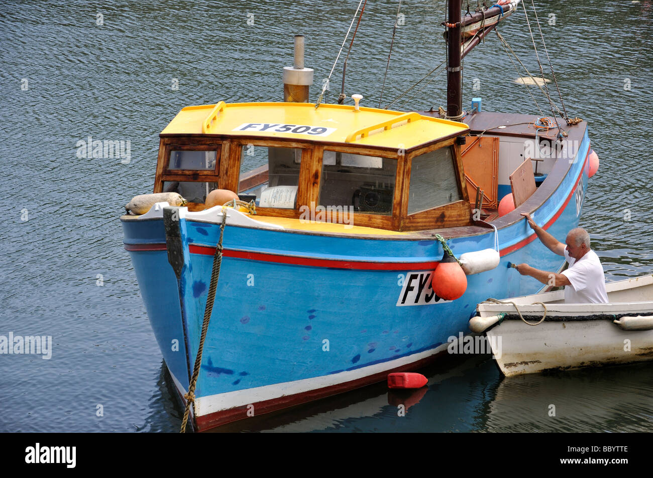 Mann-Malerei-Boot im Hafen, Mevagissey, Cornwall, England, Vereinigtes Königreich Stockfoto