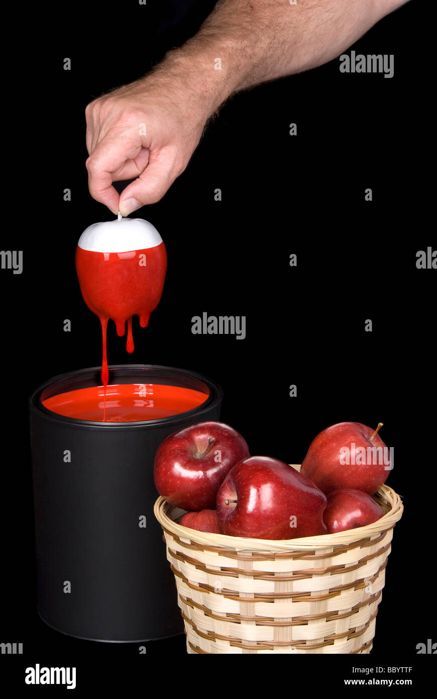 Konzeptbild eines Mannes weiße Äpfel in roter Farbe getaucht, essbare rote Äpfel in einem Korb zu bilden Stockfoto