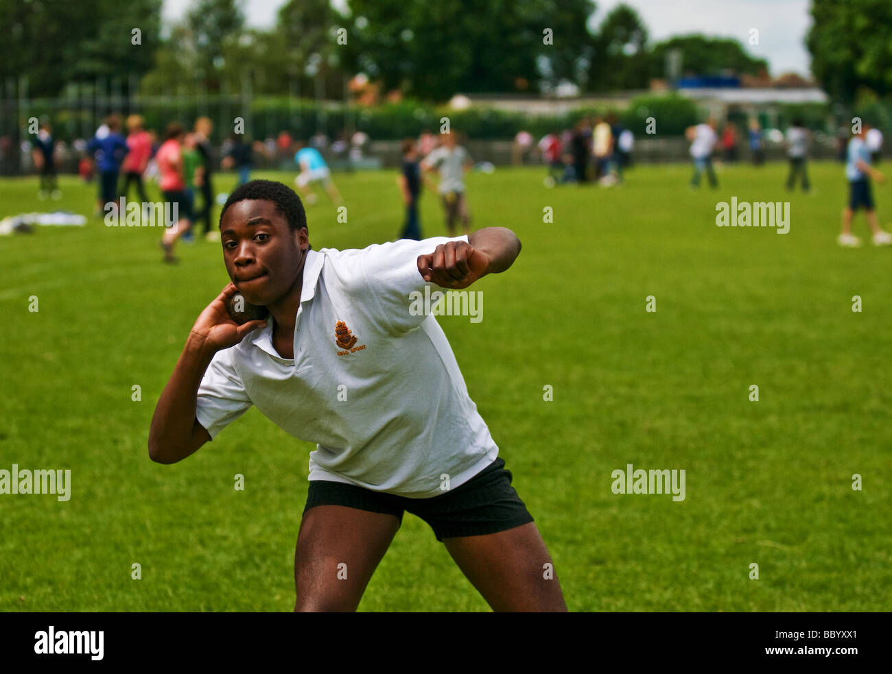 Ein Schüler, der den Schuss übte, legte ihn auf ein Schulsportfeld Stockfoto