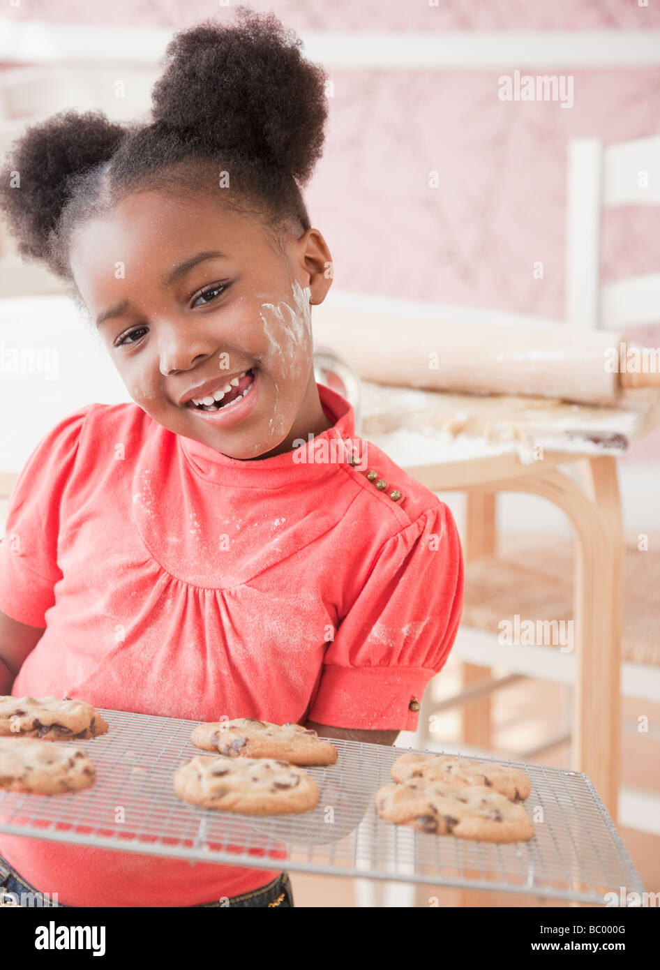 Afrikanische Mädchen hält frisch gebackene Kekse Stockfoto