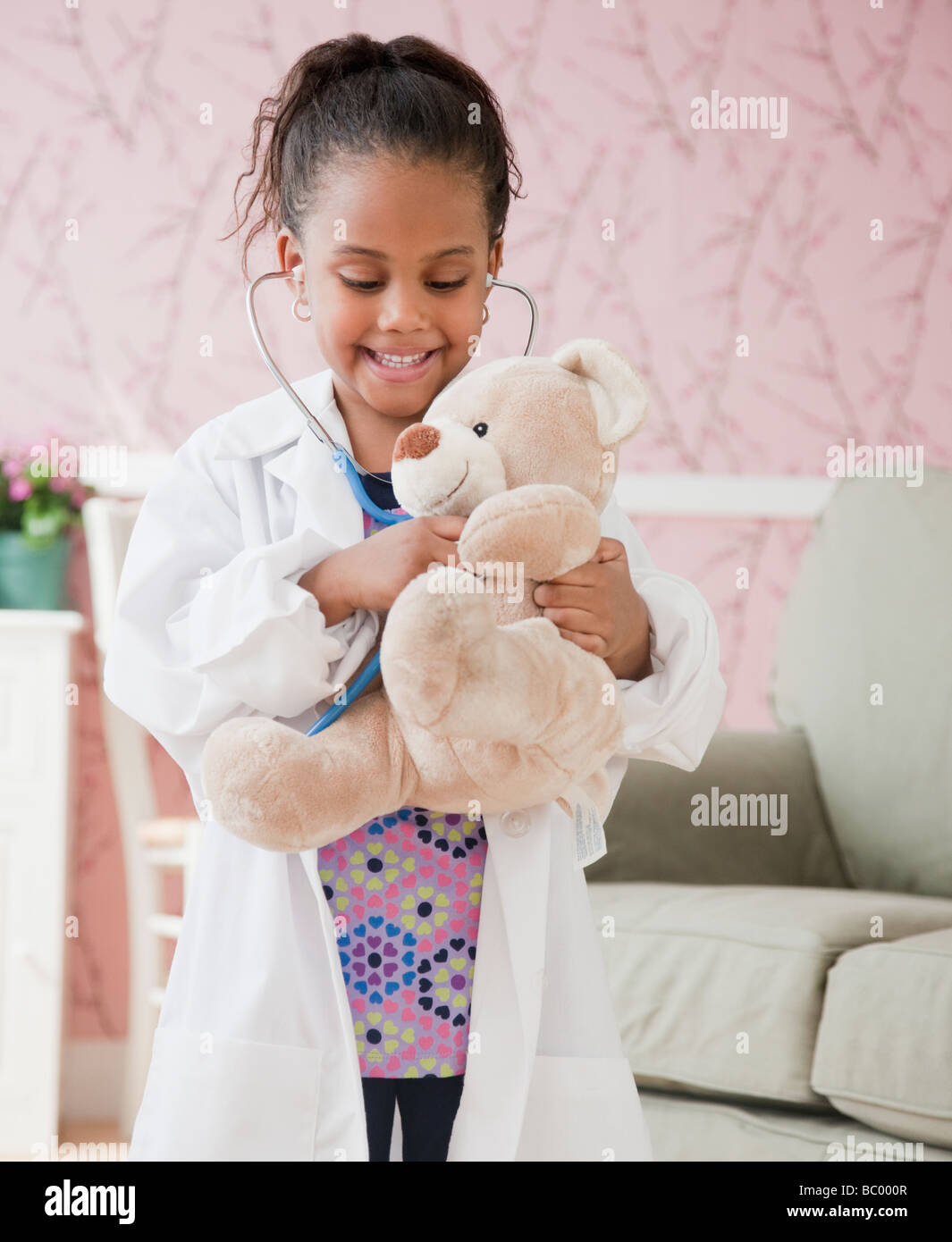 Afrikanische Mädchen spielen Arzt mit Teddybär Stockfoto