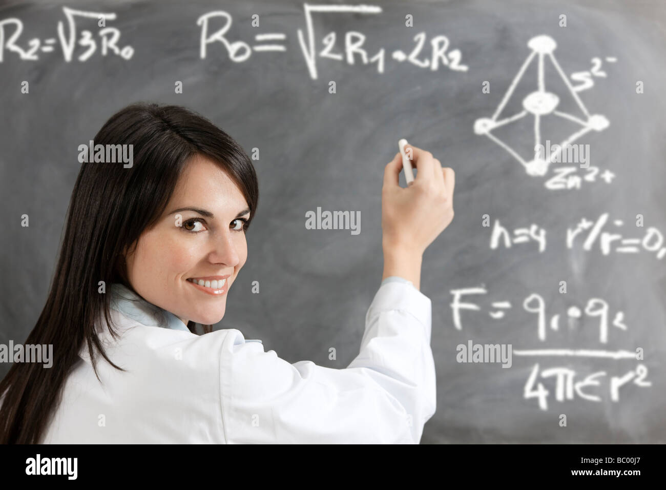 weibliche Lehrer Formeln an Tafel schreiben Stockfoto
