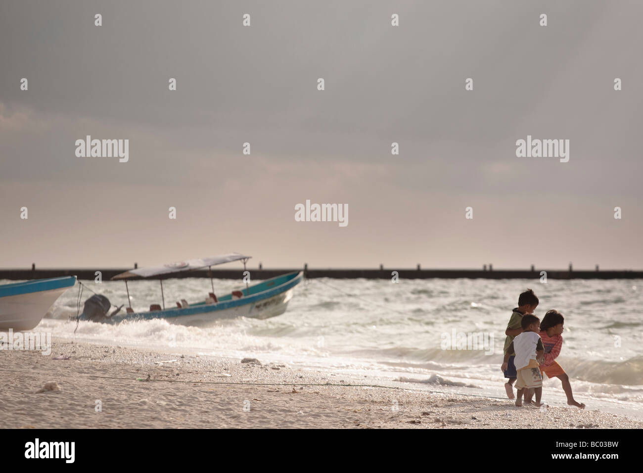 Drei Kinder spielen am Strand in Celestœn, Yucatan, Mexiko. Stockfoto