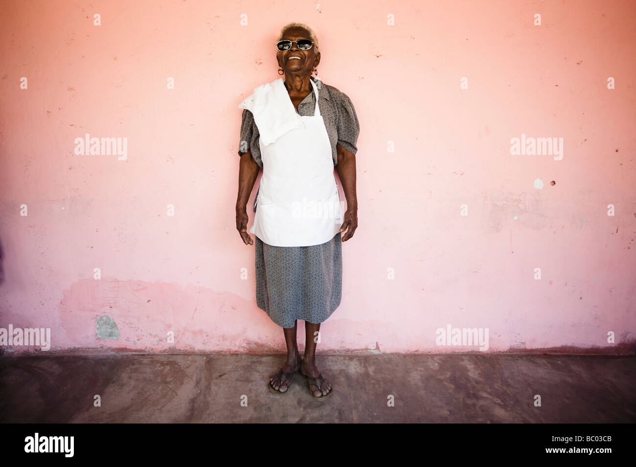 Eine Frau steht über eine rosa Wand in der Gemeinschaft der Charco Redondo, Oaxaca, Mexiko. Stockfoto