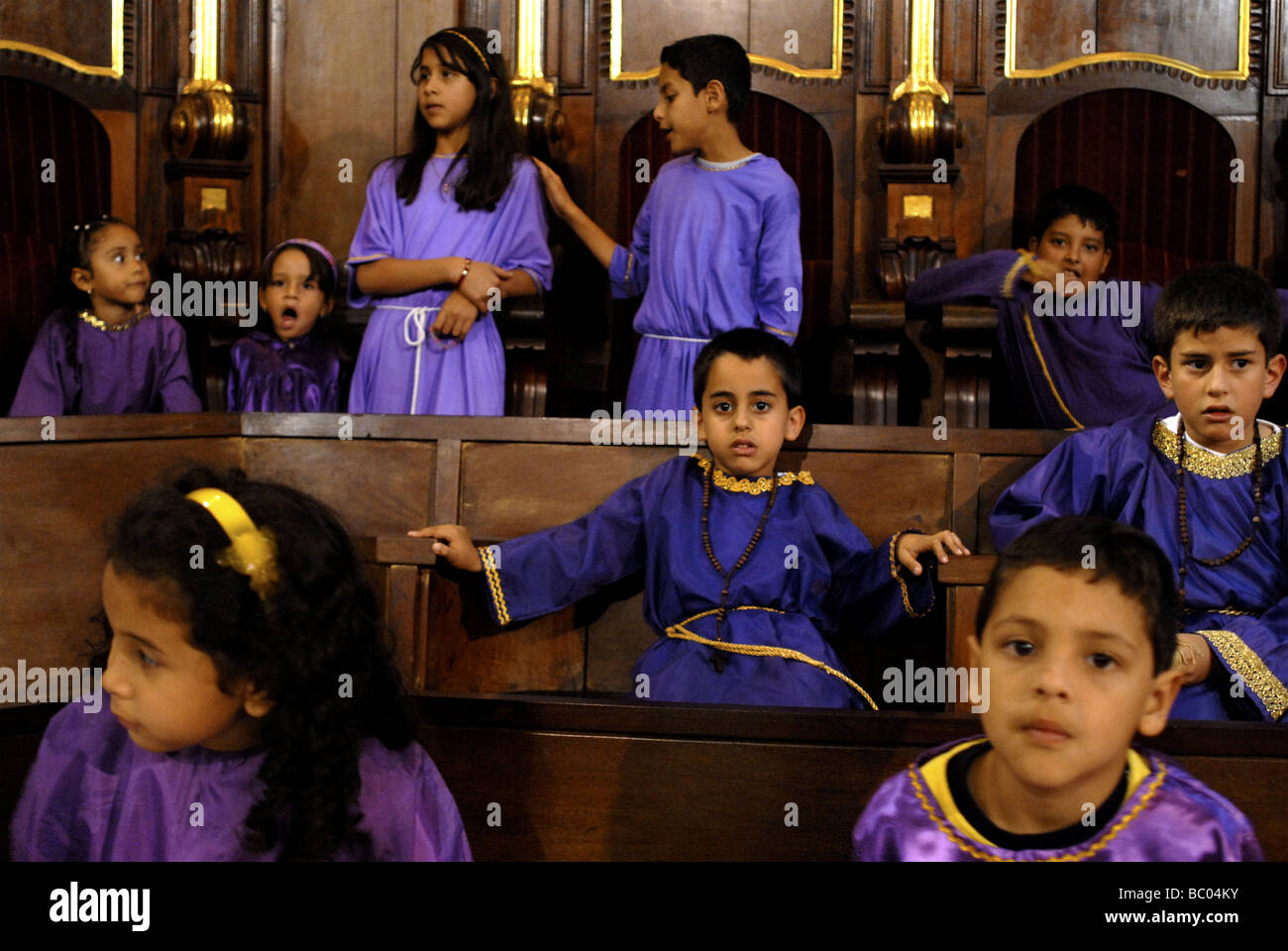 Kinder besuchen Karwoche Masse gekleidet in traditionellen lila Roben in Merida, Venezuela. Stockfoto