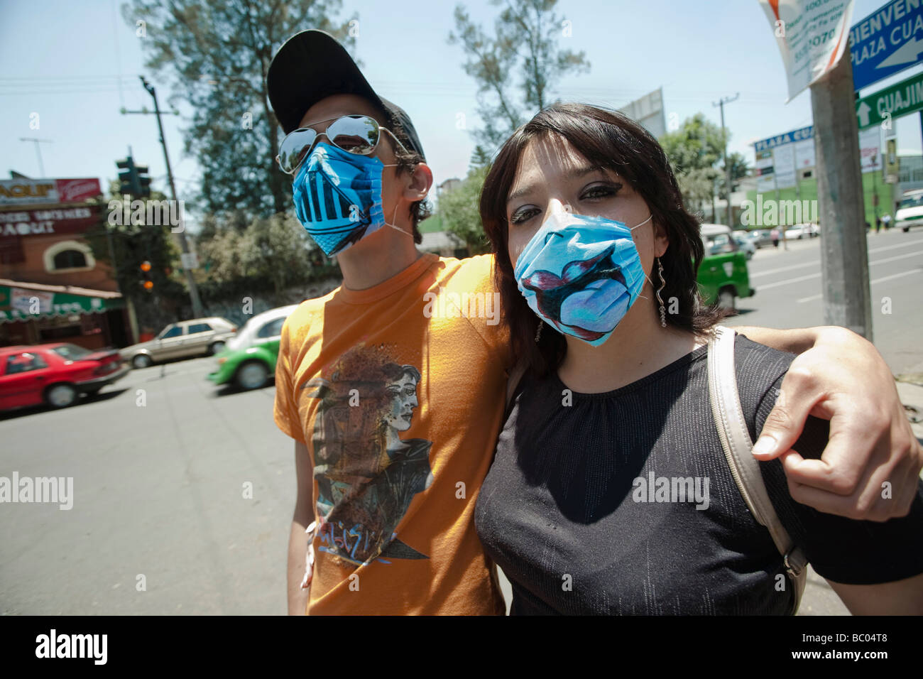 Ein junges Paar trägt lustigste bemalte Masken auf der Straße während der Schweinegrippe-Epidemie in Mexiko-Stadt, DF, Mexiko. Stockfoto