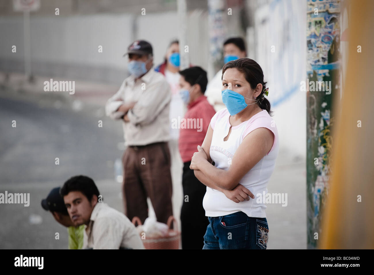 Menschen tragende Masken stehen an einer Bushaltestelle während der Schweinegrippe-Epidemie in Mexiko-Stadt, DF, Mexiko. Stockfoto